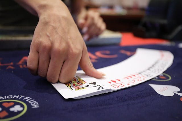 A dealer shows cards at the casino table.